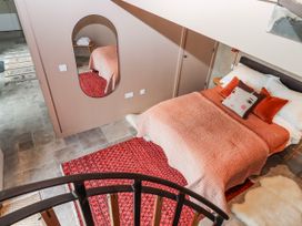 A bedroom with a bed and mirror at 3 Caddaford Barns in Buckfastleigh