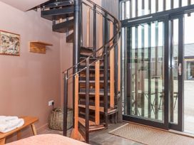 An entryway with a spiral staircase and a glass door at 3 Caddaford Barns Buckfastleigh