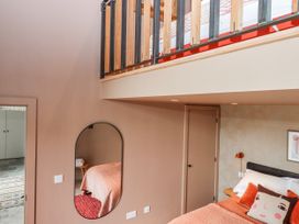 A bedroom with a bed and mirror at 3 Caddaford Barns in Buckfastleigh