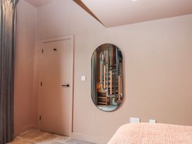 A bedroom with a mirror and stairs visible at 3 Caddaford Barns Buckfastleigh