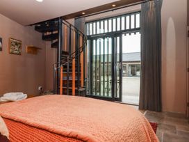 A bedroom with a spiral staircase leading to an outdoor area at 3 Caddaford Barns Buckfastleigh