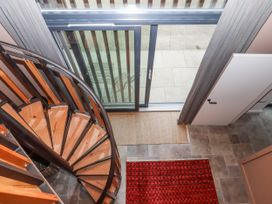 A stairwell with a spiral staircase and a door at 3 Caddaford Barns Buckfastleigh