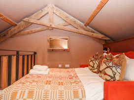 A bedroom with a bed and cushions at 3 Caddaford Barns Buckfastleigh