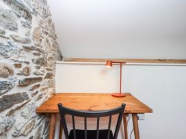 A workspace with a desk and a lamp at 3 Caddaford Barns Buckfastleigh