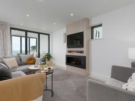 A living room with a television and coffee table at Monowai Heights in Carbis Bay