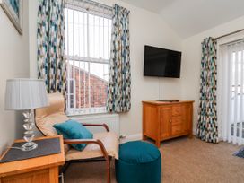 A living room with a television and armchair at 50 West Street Edelweiss Scarborough