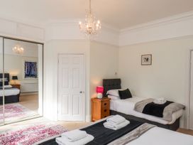 A bedroom with two beds and a chandelier at 50 West Street Edelweiss Scarborough