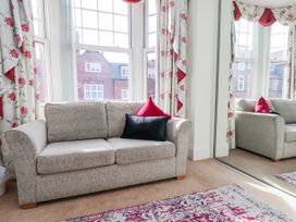 A living room with a sofa and a mirror at 50 West Street Edelweiss Scarborough