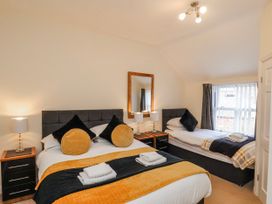 A bedroom with two beds and a mirror at 50 West Street Edelweiss Scarborough