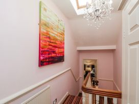 A hallway with a staircase and painting at 50 West Street Edelweiss in Scarborough