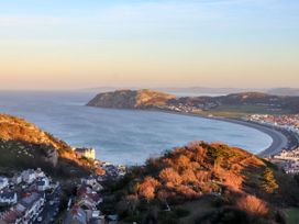 A coastal view with hills and a beach at The Keep in Llandudno