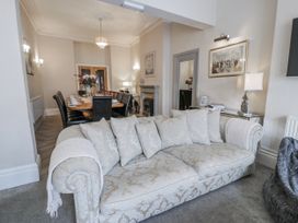 A living room with a sofa and a dining table at The Keep in Llandudno