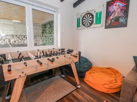 A games room with a foosball table and dartboard at The Keep in Llandudno