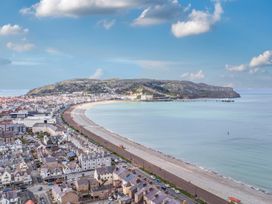 A coastal view of the beach and town with mountains at The Keep in Llandudno