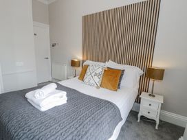 A bedroom with a bed and nightstand at The Keep in Llandudno