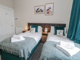 A bedroom with twin beds and wall art at The Keep in Llandudno