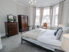 A bedroom with a bed and wardrobe at The Keep in Llandudno