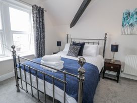 A bedroom with a metal bed and bedside table at The Keep in Llandudno