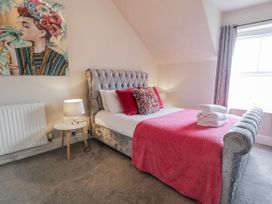 A bedroom with a bed and side table at The Keep in Llandudno