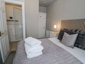 A bedroom with a bed and towels at The Keep in Llandudno