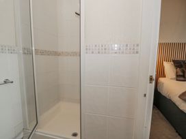 A shower and a door leading to a bedroom at The Keep in Llandudno