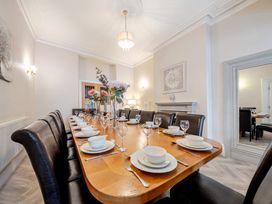 A dining room with a long table set for dinner at The Keep in Llandudno