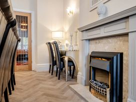 A dining room with a fireplace and table and chairs at The Keep in Llandudno