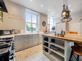 A kitchen with appliances and storage at The Keep in Llandudno