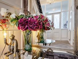 A hallway with flowers in a vase and a monkey statue at The Keep in Llandudno