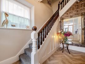 A hallway with a staircase and decorative items at The Keep in Llandudno