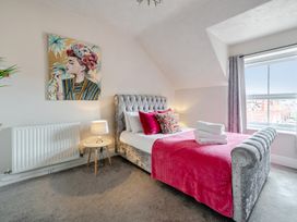 A bedroom with a bed and a painting on the wall at The Keep in Llandudno