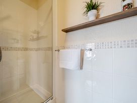 A bathroom with a shower and towel on a rack at The Keep in Llandudno