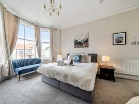A bedroom with a bed and a sofa at The Keep in Llandudno