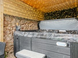 A hot tub with glasses and a bottle in an outdoor area at The Keep in Llandudno