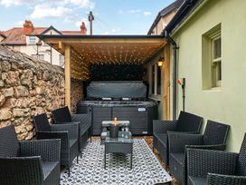 An outdoor seating area with a hot tub and chairs at The Keep in Llandudno