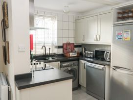 A kitchen with a washing machine dishwasher microwave toaster and refrigerator at The White House in Torquay