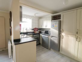 A kitchen with white cabinets stainless steel appliances and a window at The White House in Torquay