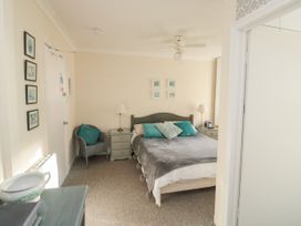 A bedroom with a bed and bedside tables with lamps and cushions at The White House in Torquay