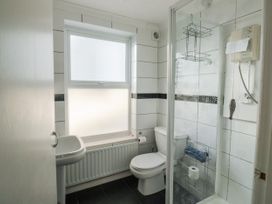 A bathroom with a toilet sink and a shower with glass doors at The White House in Torquay