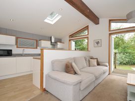 A living room with a sofa and kitchen area at 3 Southern Place in Dobwalls