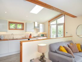 A living room with a kitchen area and a sofa at 5 Faraway Fields in Dobwalls