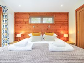 A bedroom with a double bed and wooden wall at 5 Faraway Fields in Dobwalls