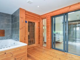 A bathroom with a bathtub and a sauna at 5 Faraway Fields in Dobwalls