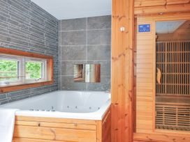 A bathroom with a bath tub and a sauna at 5 Faraway Fields in Dobwalls