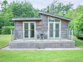A cottage with a deck and chairs at 5 Faraway Fields Dobwalls