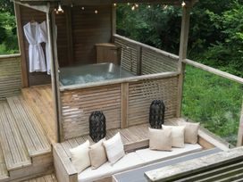 An outdoor area with a hot tub and wooden deck at 24 Meadow Retreat in Dobwalls