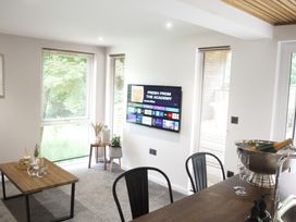 A living room with a television and dining table at 24 Meadow Retreat in Dobwalls