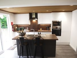 A kitchen with an island and stools at 24 Meadow Retreat in Dobwalls