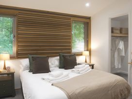 A bedroom with a bed, lamps, and a closet at 24 Meadow Retreat in Dobwalls