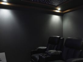 A home theater with recliner chairs and ceiling lights at 24 Meadow Retreat in Dobwalls
